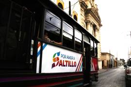El tranvía recorre calles mojadas del Centro Histórico mientras pasajeros observan la ciudad entre luces y reflejos tras la lluvia.