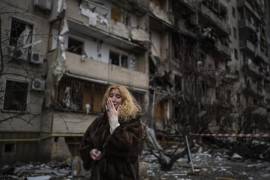 Natali Sevriukova llora frente a su edificio de apartamentos destruido en un ataque con cohetes en Kiev, Ucrania, el 25 de febrero de 2022.