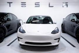 Un vehículo Tesla Model 3, en el centro, flanqueado por dos vehículos Model Y que son utilizados por un concesionario Tesla como vehículos de prueba, se ve estacionado en un garaje en Washington, DC. EFE/EPA/Michael Reynolds