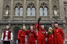 Personas disfrazadas de la serie española de “La Casa del Papel” protestan durante un mitin de opositores a la ley COVID-19 en la Bundesplatz en Berna, Suiza. EFE/EPA/Anthony Anex
