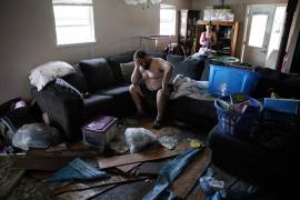 Josh Montford apoya la cabeza en una mano mientras examina los destrozos que el huracán Ida causó en su casa en Jean Lafitte, Luisiana. AP/John Locher