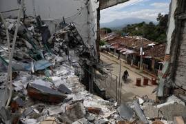 Un hombre pasa en motocicleta junto a las ruinas de casas destruidas cinco meses antes en un ataque de disidentes de las antiguas Fuerzas Amadas Revolucionarias de Colombia en Buenos Aires, Cauca, Colombia.