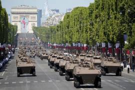 Vehículos militares conducen por la avenida de los Campos Elíseos durante el desfile del Día de la Bastilla en París, Francia