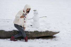 Este martes se pronosticaban nevadas en los estados de Nueva York y Nueva Inglaterra. En la imagen, una persona se toma una foto con un muñeco de nieve en Central Park.