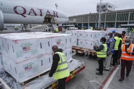 Varios funcionarios reciben cajas de la vacuna de Moderna contra el coronavirus después de su llegada al aeropuerto de Nairobi, Kenia, el lunes 6 de septiembre de 2021. Las dosis son parte de las vacunas donadas por Estados Unidos a través del programa COVAX. AP/Brian Inganga