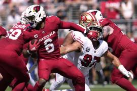 Arizona Cardinals running back James Conner, left, fends off San Francisco 49ers defensive end Nick Bosa during the first half of an NFL football game Sunday, Sept. 21, 2025, in Santa Clara. (AP Photo/Godofredo A. Vásquez)