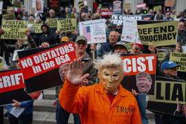Una persona que lleva una máscara que representa al presidente de EU, Donald Trump, y un uniforme de presidiario de color naranja, participa en una manifestación bajo el lema “No Kings” en Nueva York.