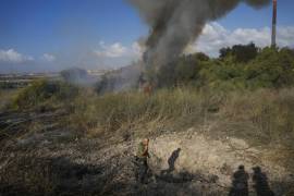 Un agente de policía inspecciona la zona en torno a un incendio después de que el ejército dijera haber lanzado proyectiles para interceptar un misil lanzado desde Yemen.