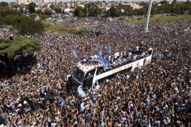 El equipo de fútbol argentino que ganó el título de la Copa del Mundo viaja en un autobús abierto durante su desfile de bienvenida en Buenos Aires, Argentina.