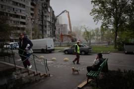 Un grupo de personas pasa por delante de un edificio dañado en Járkov, Ucrania, una ciudad que sufre ataques casi a diario.