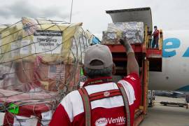 Operarios cargando suministros esenciales en un avión para su envío a las comunidades devastadas por el terremoto de Venezuela.