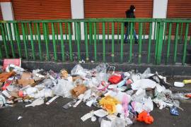 Una mujer camina cerca de una acumulación de basura dejada sobre avenida Tlalpan, Ciudad de México.