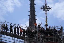Trabajadores celebran tras la instalación de la Croix du Chevet de la catedral de Notre Dame de París.