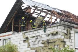 Los bomberos se reúnen en un tejado destruido para inspeccionar una casa dañada, después de que varios drones rusos atacaran, en Wyryki, cerca de Lublin, Polonia.