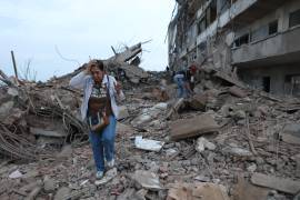 Residentes caminan entre los escombros de edificios dañados por los terremotos del día anterior en Catia La Mar, Venezuela, el jueves 25 de junio de 2026.