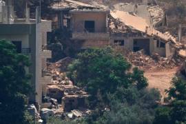 Vehículos militares israelíes (a la izquierda) yacen apostados entre viviendas en la localidad de Zawtar al-Sharqiyah —ocupada por fuerzas israelíes—, en esta fotografía captada desde el pueblo de Zawtar al-Gharbieh.