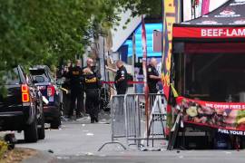 Un fotógrafo de escena de crimen llega mientras las fuerzas de seguridad investigan el lugar de un tiroteo en el Seattle Center durante el festival gastronómico Bite of Seattle el domingo 26 de julio de 2026 en Seattle.