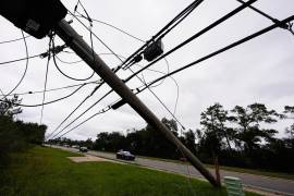 Agentes de la Policía Estatal pasan junto a líneas eléctricas derribadas tras el paso del huracán Isaias en Milton, Florida, el sábado 10 de octubre de 2026.