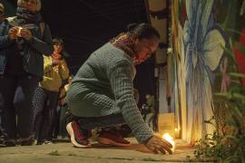 Una persona coloca una vela en un mural por la memoria del padre Marcelo Pérez, en San Cristóbal de las Casas Chiapas.