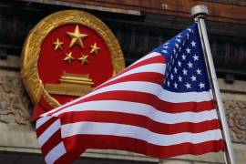 Una bandera estadounidense ondea junto al emblema nacional chino durante una ceremonia de bienvenida a Donald Trump, de visita en China, frente al Gran Salón del Pueblo en Pekín, el 9 de noviembre de 2017.