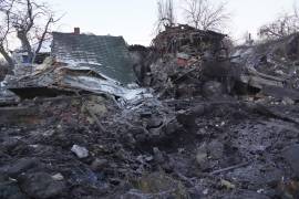 Un cráter de una bomba aérea se ve en primer plano sobre casas privadas destruidas tras un ataque aéreo ruso en Járkov, Ucrania, el lunes 19 de enero de 2026.