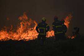 Bomberos rocían agua en un incendio forestal cerca de Lacanau, en el suroeste de Francia, el sábado 25 de julio de 2026.