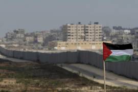 Una bandera palestina con el fondo de una sección del muro en el corredor de Filadelfia entre Egipto y Gaza, al fondo, cerca de la ciudad de Rafah, en el sur de la Franja de Gaza.