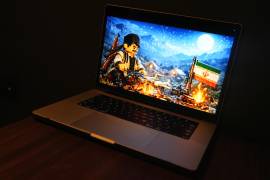 En la pantalla de la laptop se ve una animación generada por IA creada por un estudio pro-Irán que muestra a un iraní asando cuatro aviones estadounidenses sobre una hoguera, en Bruselas.