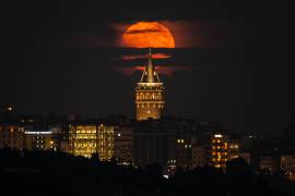 Una superluna se eleva detrás de la Torre de Gálata en Estambul, Turquía.