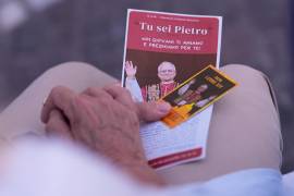 Una mujer sostiene fotografías del papa León XIV mientras reza en el Policlínico Agostino Gemelli, donde el pontífice se encuentra hospitalizado, en Roma, el jueves 15 de octubre de 2026.