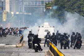 Elementos de la Policía Nacional Bolivariana y la Guardia Nacional Bolivariana enfrentan a manifestantes contra los resultados de las elecciones presidenciales del domingo, en Caracas.