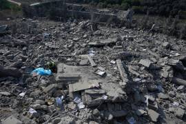 Un rescatista, a la izquierda, busca víctimas bajo los escombros de una casa que fue alcanzada por un ataque aéreo israelí en la población de Ansar.