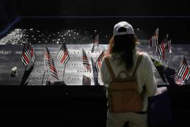 Mary Beth Delarm looks over the the names on the the 9/11 Memorial during a ceremony to mark the 24th anniversary of the 9/11 attacks, Thursday, Sept. 11, 2025, in New York. (AP Photo/Seth Wenig)