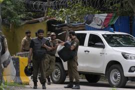 Agentes de policía se preparan para tomar posiciones en el exterior de la residencia del exprimer ministro Imran Khan, en Lahore, Pakistán.