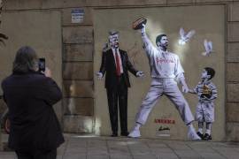 Un grafiti del artista Alberto León en el centro de Barcelona, que muestra al presidente de EU, Donald Trump, el cantante Bad Bunny toma la mano de Liam Conejo Ramos, un niño detenido por la policía el ICE.
