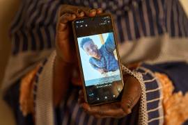 Sulafa Mustafa muestra una fotografía de su hijo desaparecido, Suleiman Abdelsaid, en Omdurman, Sudán.