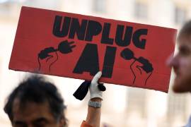 Un pequeño grupo de personas a favor de implementar restricciones a la IA sostiene pancartas frente al ayuntamiento de Nueva York.