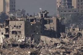 Una bandera israelí se encuentra en lo alto de un edificio destruido en la Franja de Gaza, vista desde el sur de Israel.