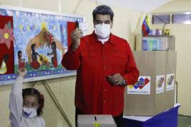 Acompañado de su nieta, el presidente de Venezuela, Nicolás Maduro, muestra su papeleta durante las elecciones regionales, en la Escuela Ecológica Bolivariana Simón Rodríguez en el barrio Fuerte Tiuna de Caracas, Venezuela. AP/Javier Vegas