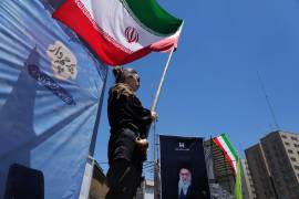 Una mujer ondea una bandera iraní durante una marcha progobierno, donde se ve la imagen del fallecido líder supremo iraní Alí Jamenei, asesinado en ataques de EU e Israel el 28 de febrero.