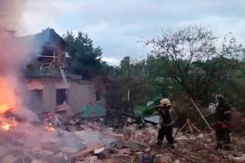 Bomberos que trabajan para extinguir un incendio en un casa dañada tras un ataque ucraniano de dron en la región de Moscú, Rusia, el lunes 13 de julio de 2026.