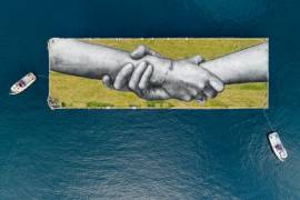 Tres grafitis de manos gigantes simbolizan la unión de Europa y Asia