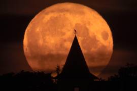 La luna llena, vista detrás de una casa en la localidad de Putilovo, a 70 kilómetros (43 millas) al este de San Petersburgo, Rusia, el 13 de julio de 2022.