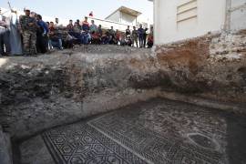 Gente observa un enorme mosaico de la era romana en Rastan, Siria. Funcionarios sirios dicen que es el descubrimiento arqueológico más importante desde el inicio del conflicto hace 11 años.