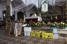 Participantes entregan ofrendas en honor a la Virgen durante la misa en el Santuario de Guadalupe.