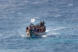 ARCHIVO - Migrantes se agolpan en una embarcación de madera mientras navegan hacia el puerto de La Restinga, el domingo 18 de agosto de 2024, en la isla canaria de El Hierro, España. (AP Foto/María Ximena, archivo)