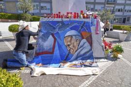 El pintor mexicano Roberto Márquez coloca un retrato del papa Francisco afuera del Hospital Gemelli de Roma,, donde el pontífice se encuentra hospitalizado. FOTO: