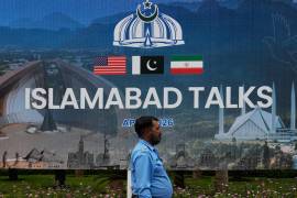 Un agente de policía pasa junto a una valla publicitaria sobre las negociaciones entre Estados Unidos e Irán, frente a un centro de atención a los medios de comunicación en Islamabad, Pakistán.