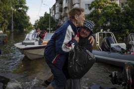 Un voluntario lleva en brazos a una mujer durante su evacuación desde la anegada localidad de Kardashynka, en la orilla izquierda del río Dniéper.