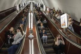 Decenas de personas aguardan en las escaleras eléctricas de una estación del metro usada como refugio durante un ataque con cohetes rusos en Kiev, Ucrania, el lunes 29 de mayo de 2023.